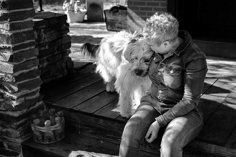 Ann met haar hond Sem op het terras van Brechts Boshuisje