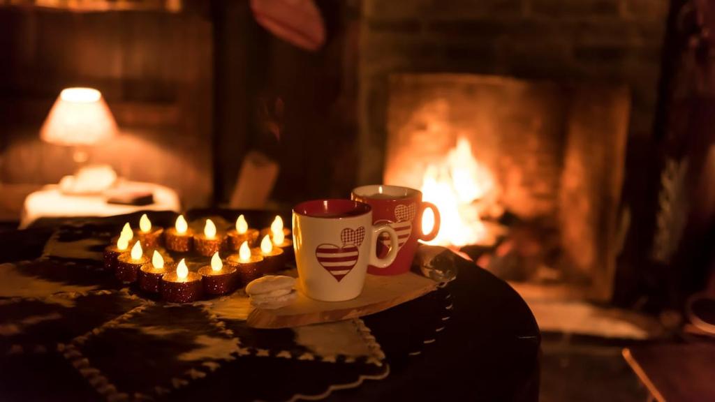 Warme drank bij het haardvuur met kaarsjes